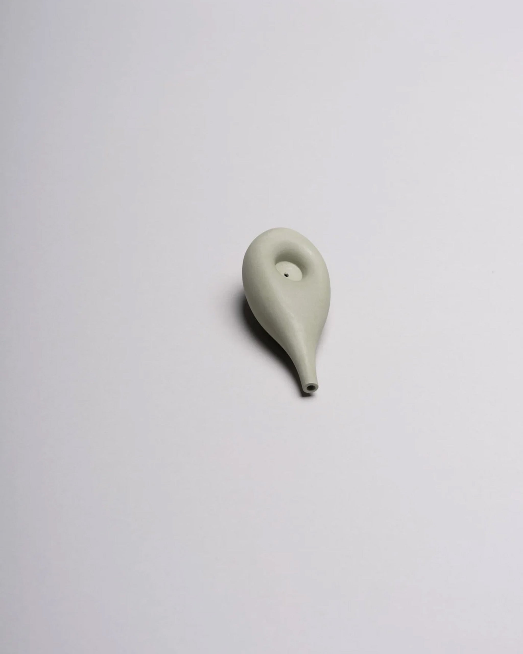 Sage porcelain glass Cloud Pipe photographed on a white background to highlight its sculptural, cloud-like form.