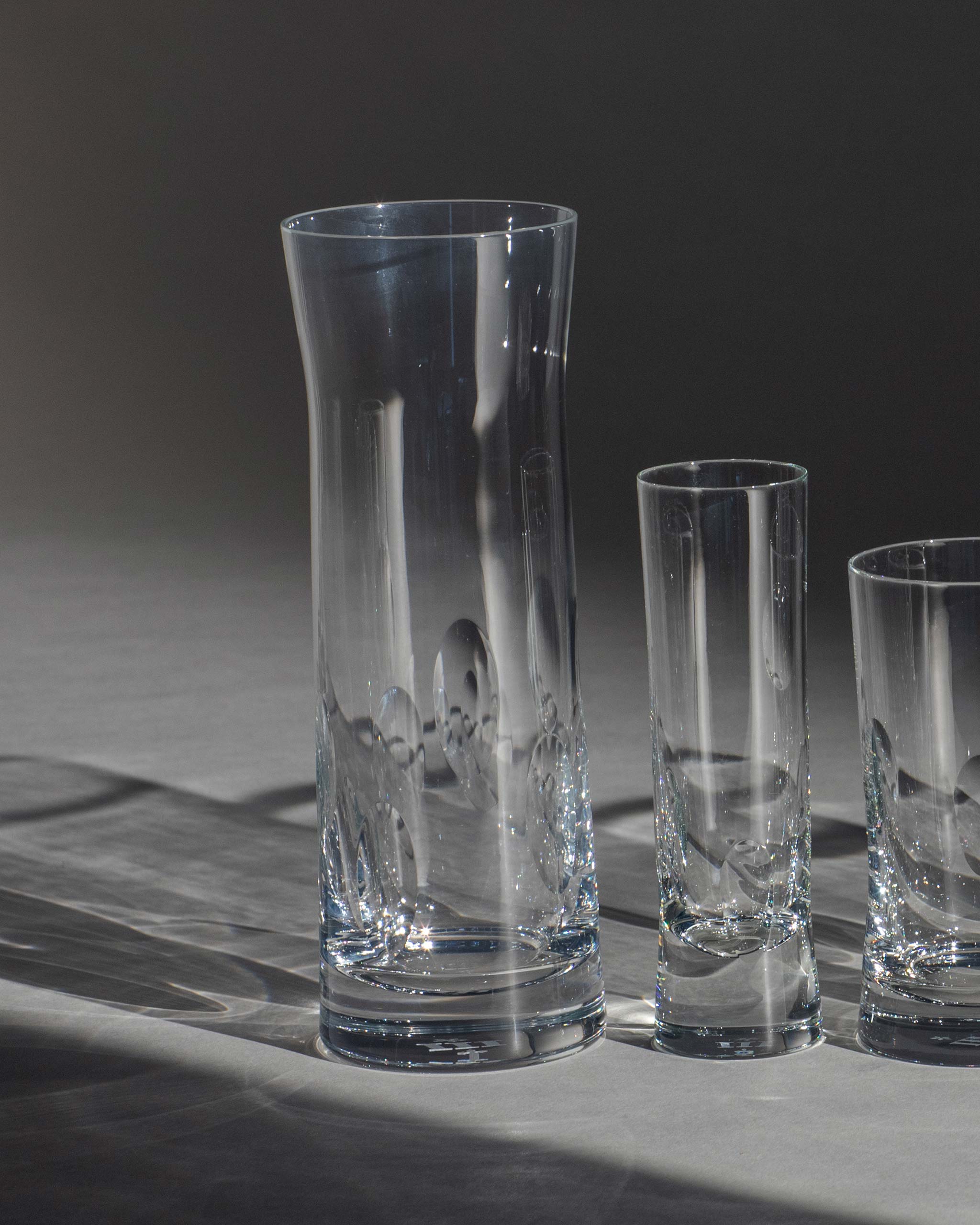 Polished hand-cut Irish crystal glasses with softly polished and sandblasted dew-cut detailing on an ambient background