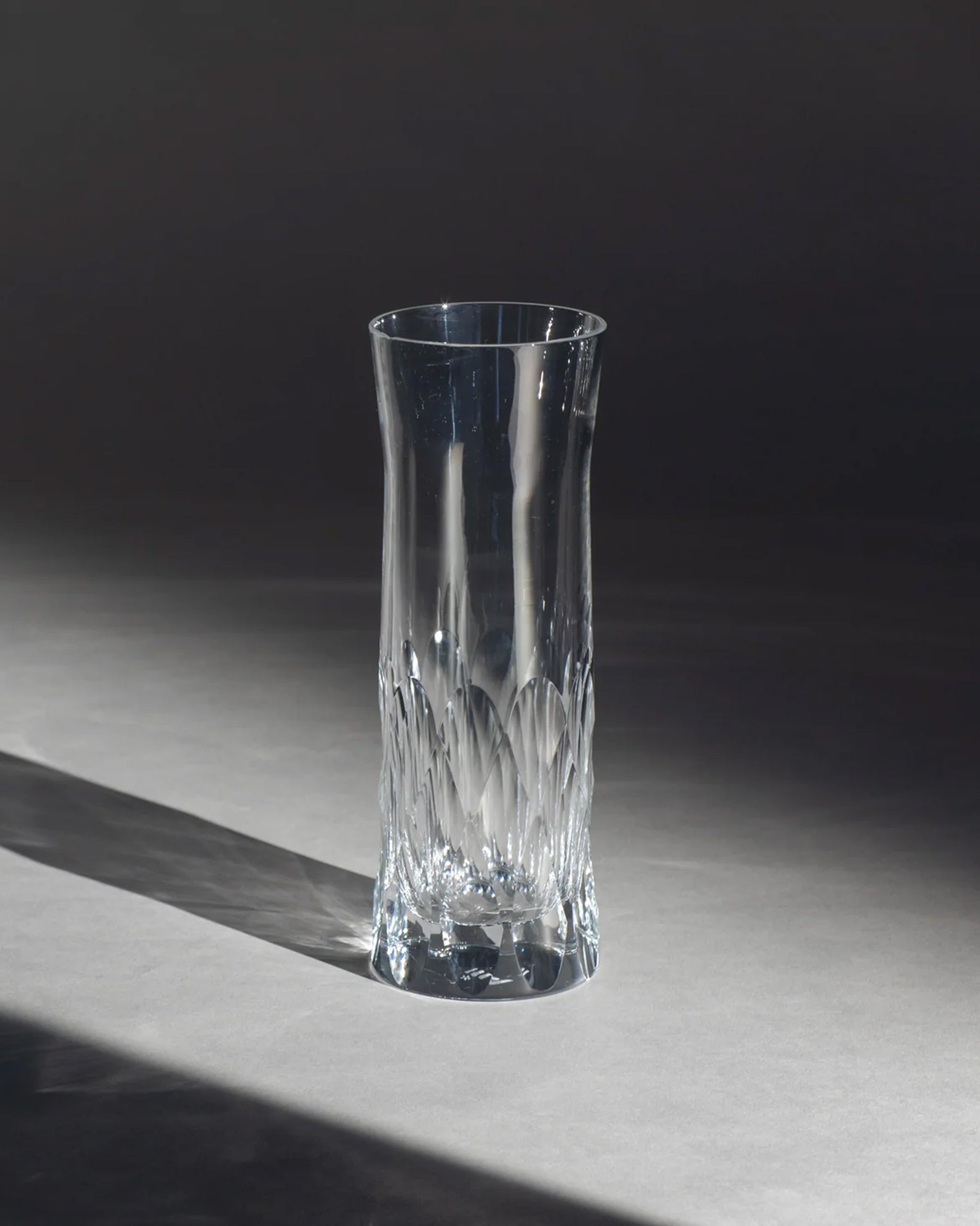 Polished hand-cut Irish crystal carafe glass with deep angular cuts inspired by ploughed soil on an ambient background