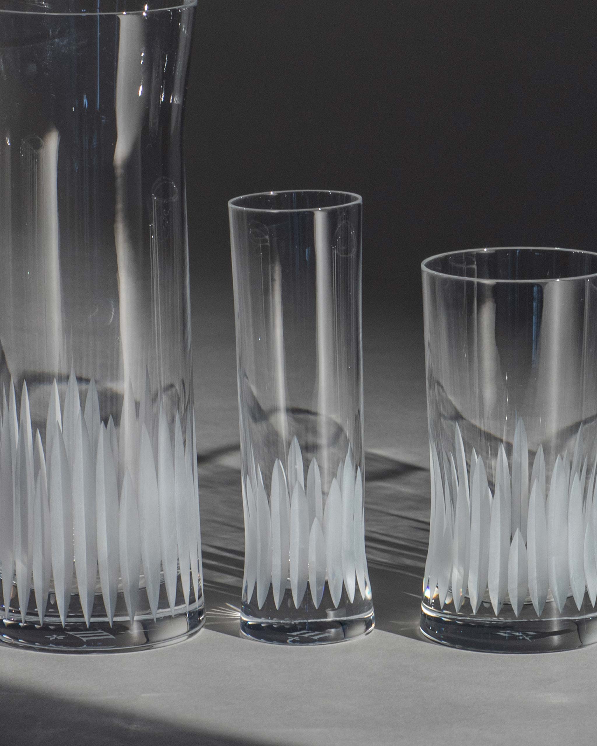 Unpolished hand-cut Irish crystal glasses with deep angular cuts inspired by ploughed soil on an ambient background