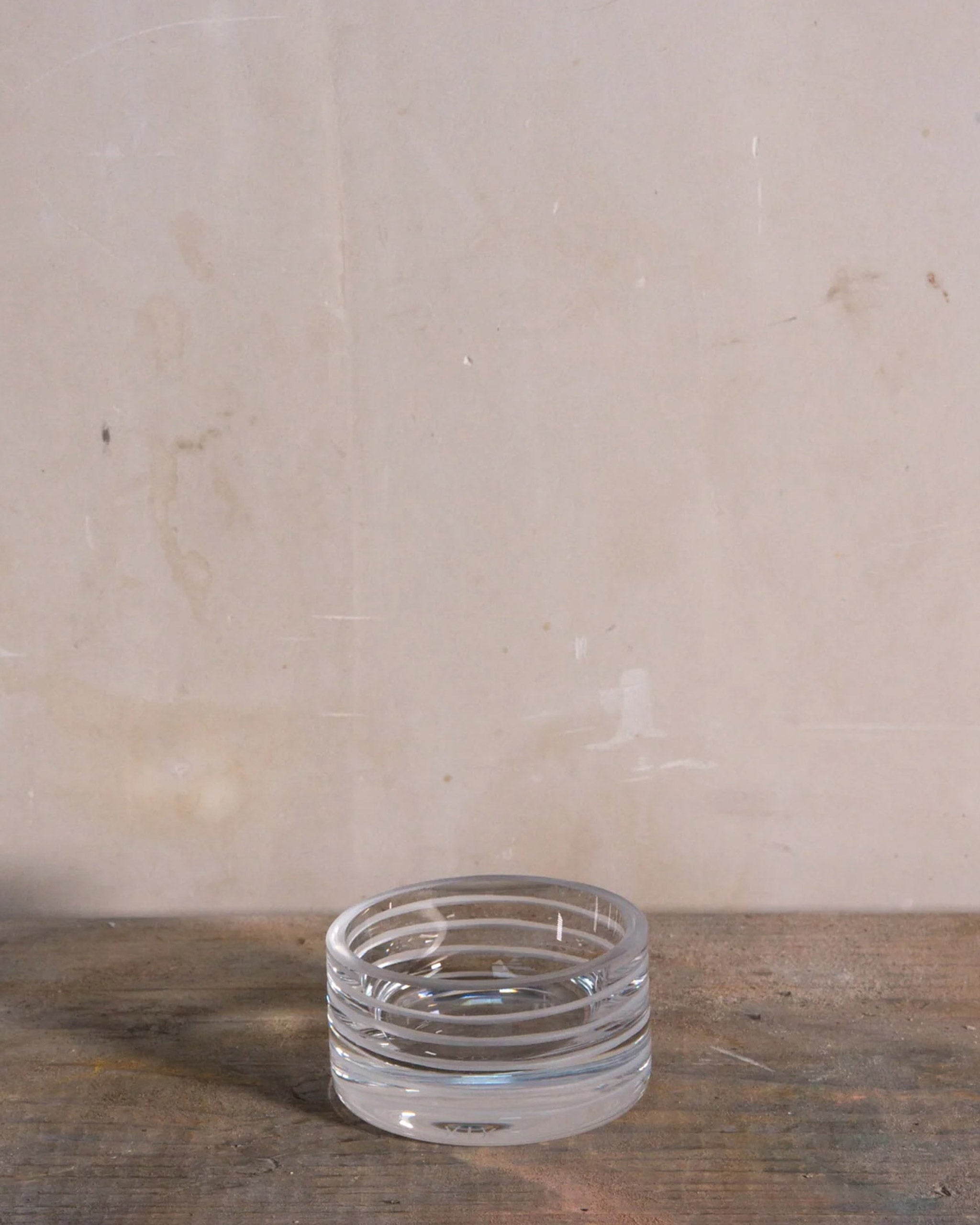 Hand-cut crystal candle holder from the Loop Collection with fine spiral cuts, displayed on a table to highlight its elegant form and light-catching texture.