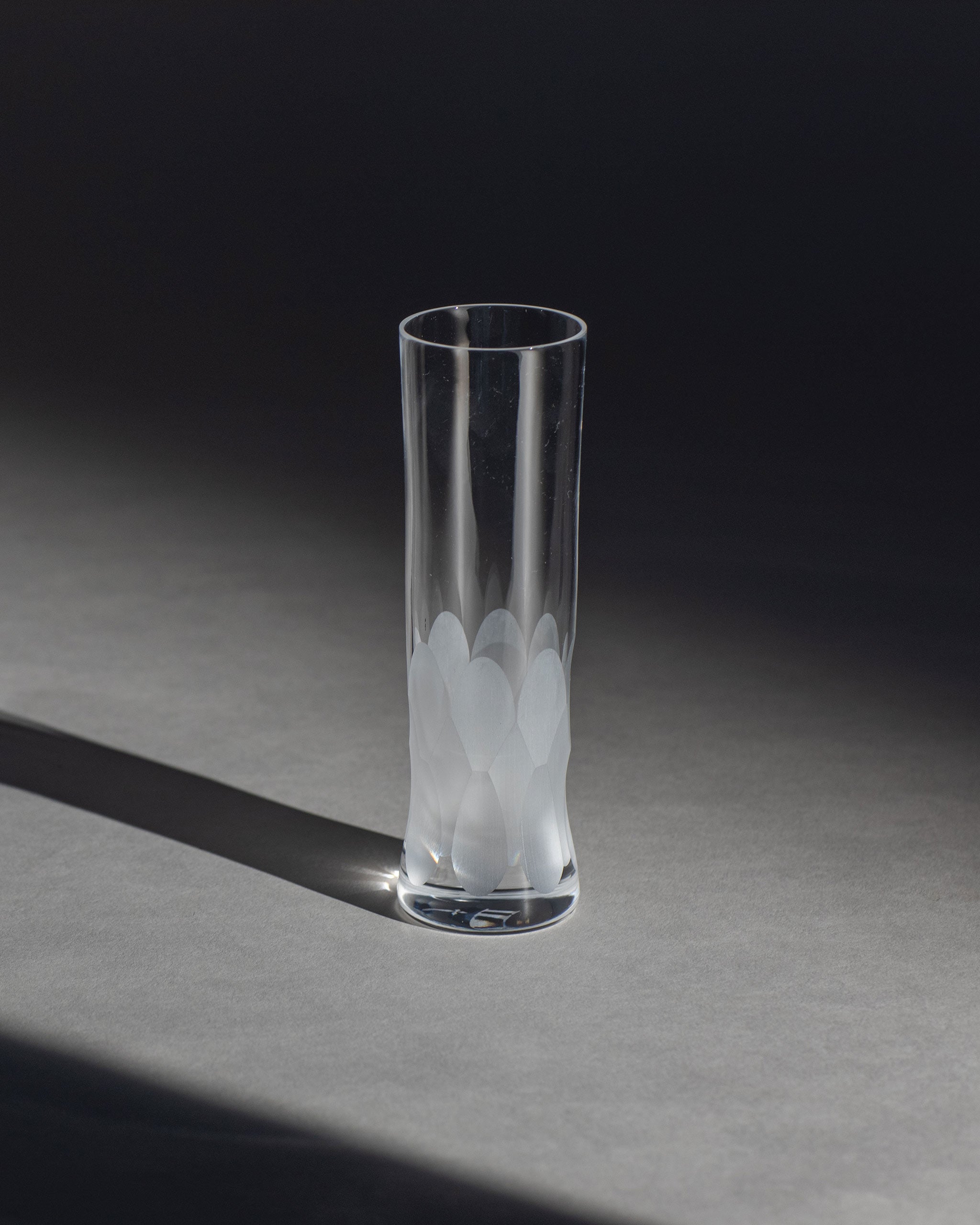 Unpolished Irish hand-blown cut crystal champagne flute with large cut pattern detailing on an ambient background