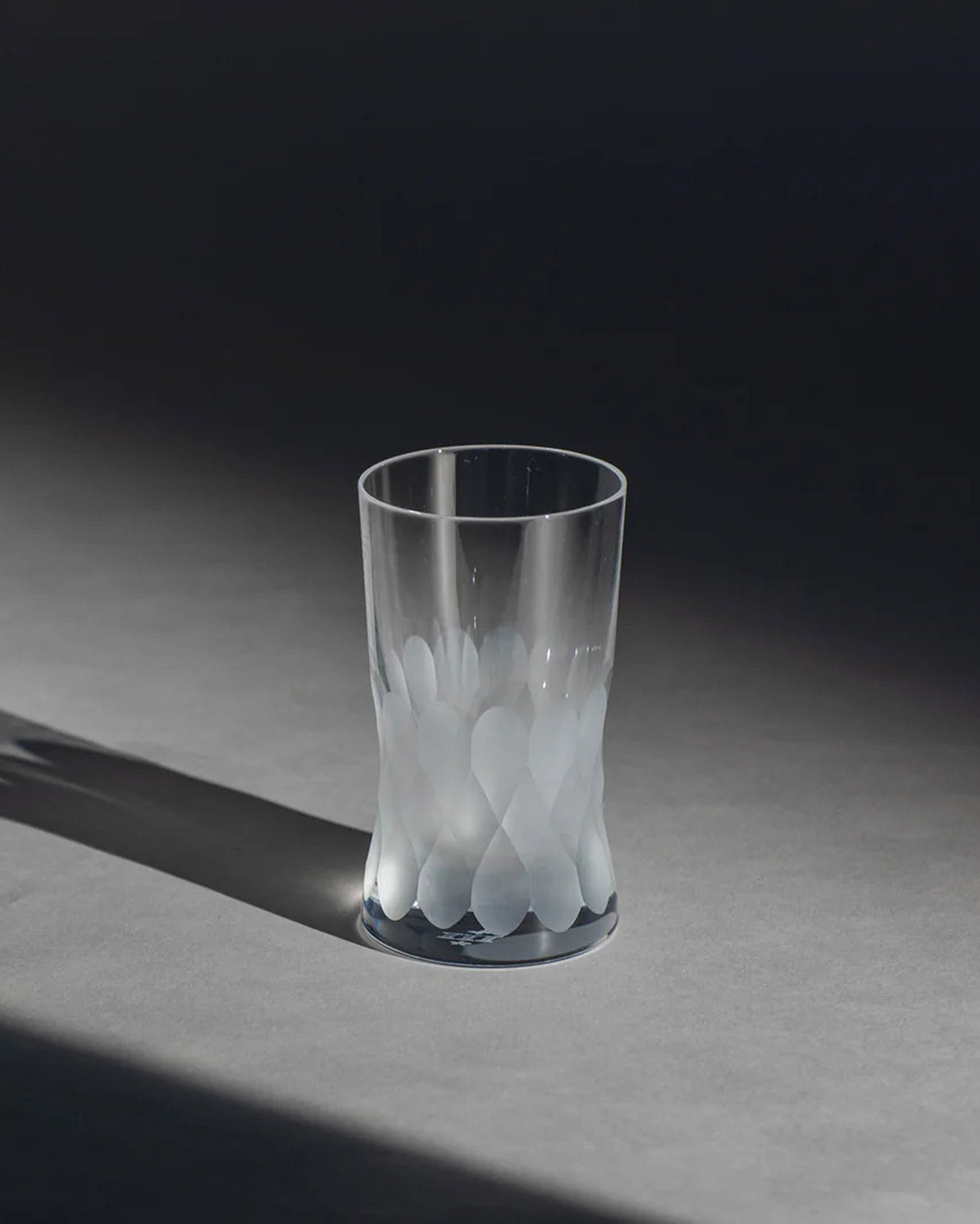 Unpolished Irish hand-blown crystal red wine glass, with interlocking cut patterns on an ambient background