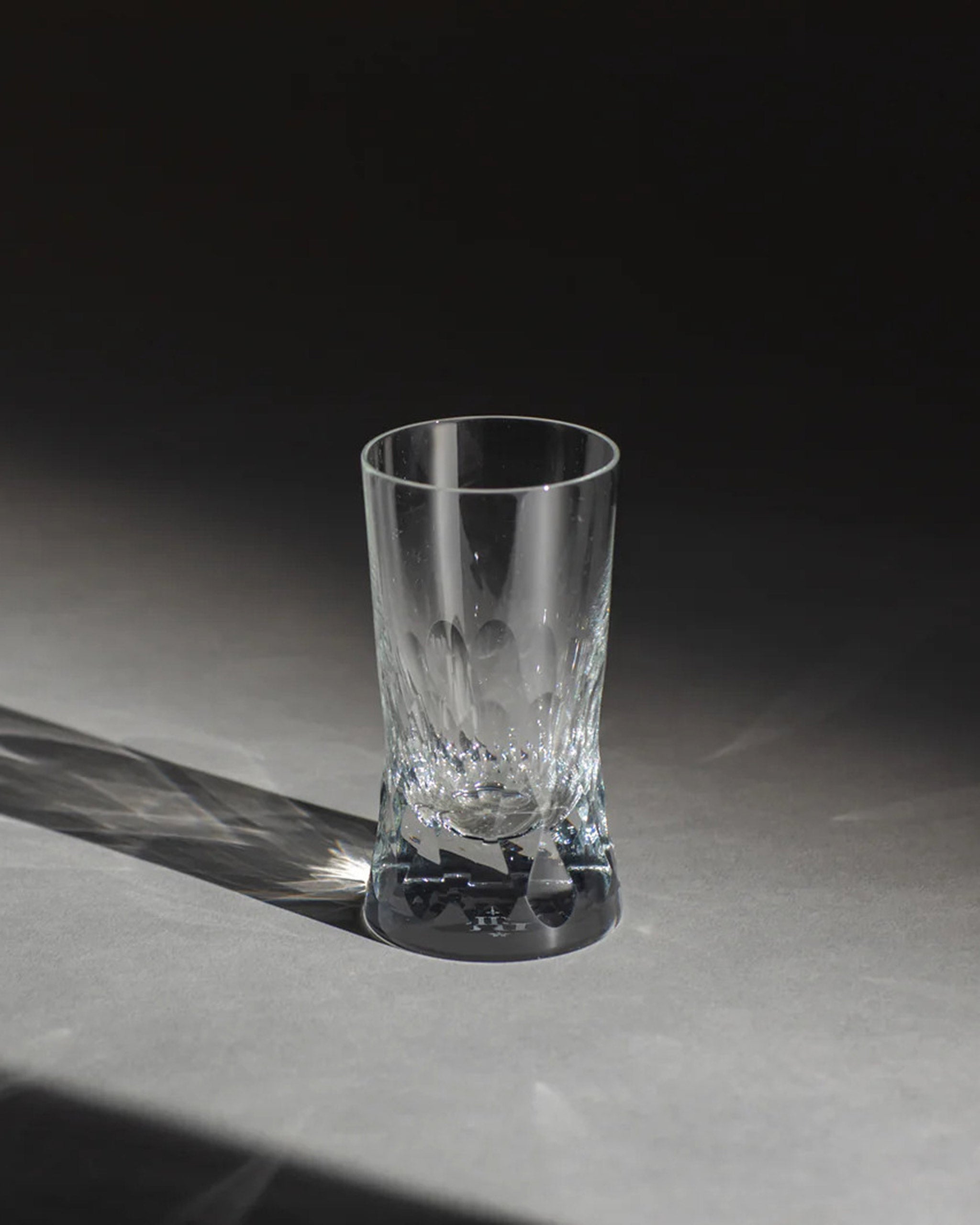 Polished Irish hand-blown cut crystal wine or water glass with large cut pattern detailing on an ambient background