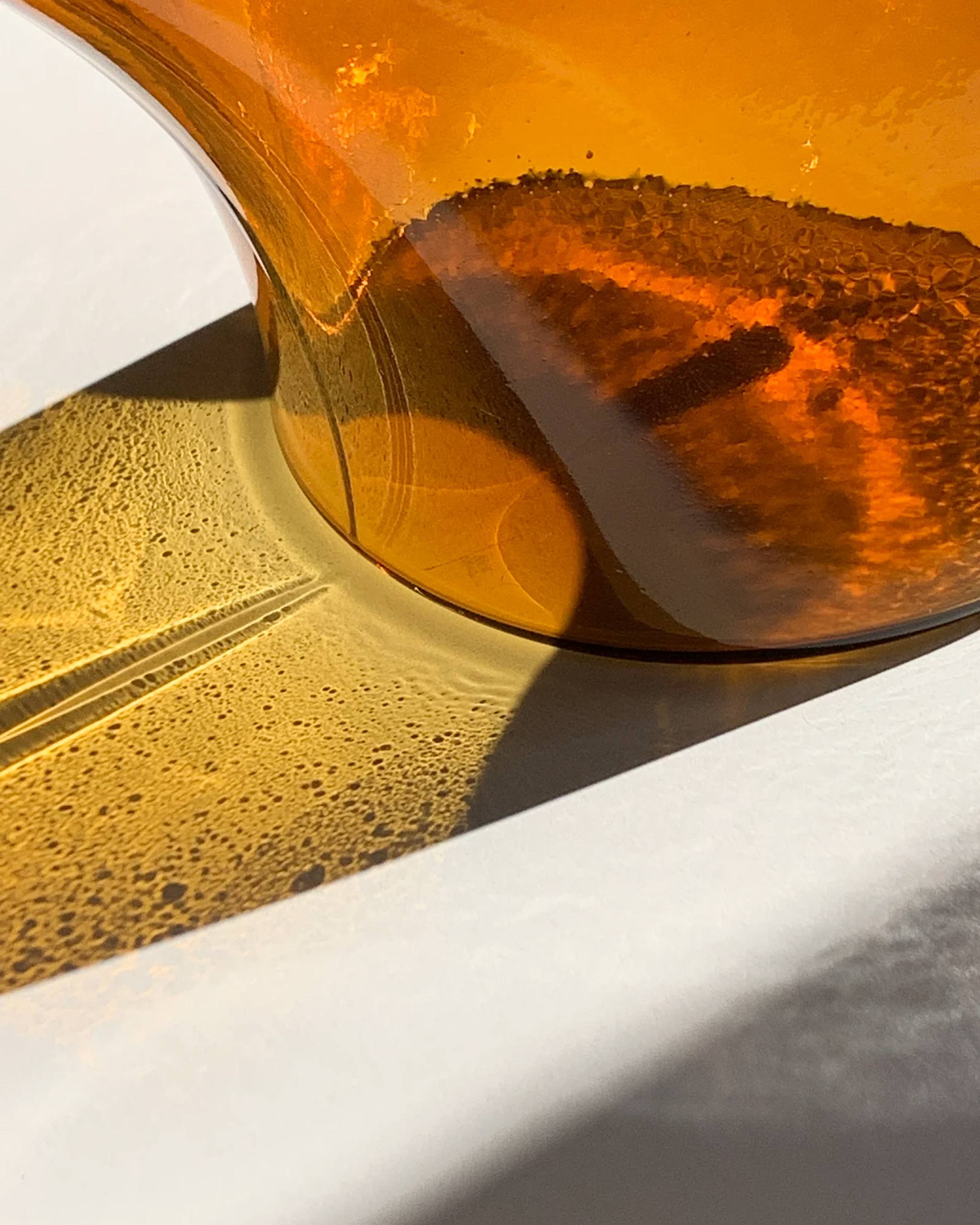 Close-up of blown glass pot showing intricate light refraction and layered texture, revealing the sculptural detailing of the kiln-cast design.