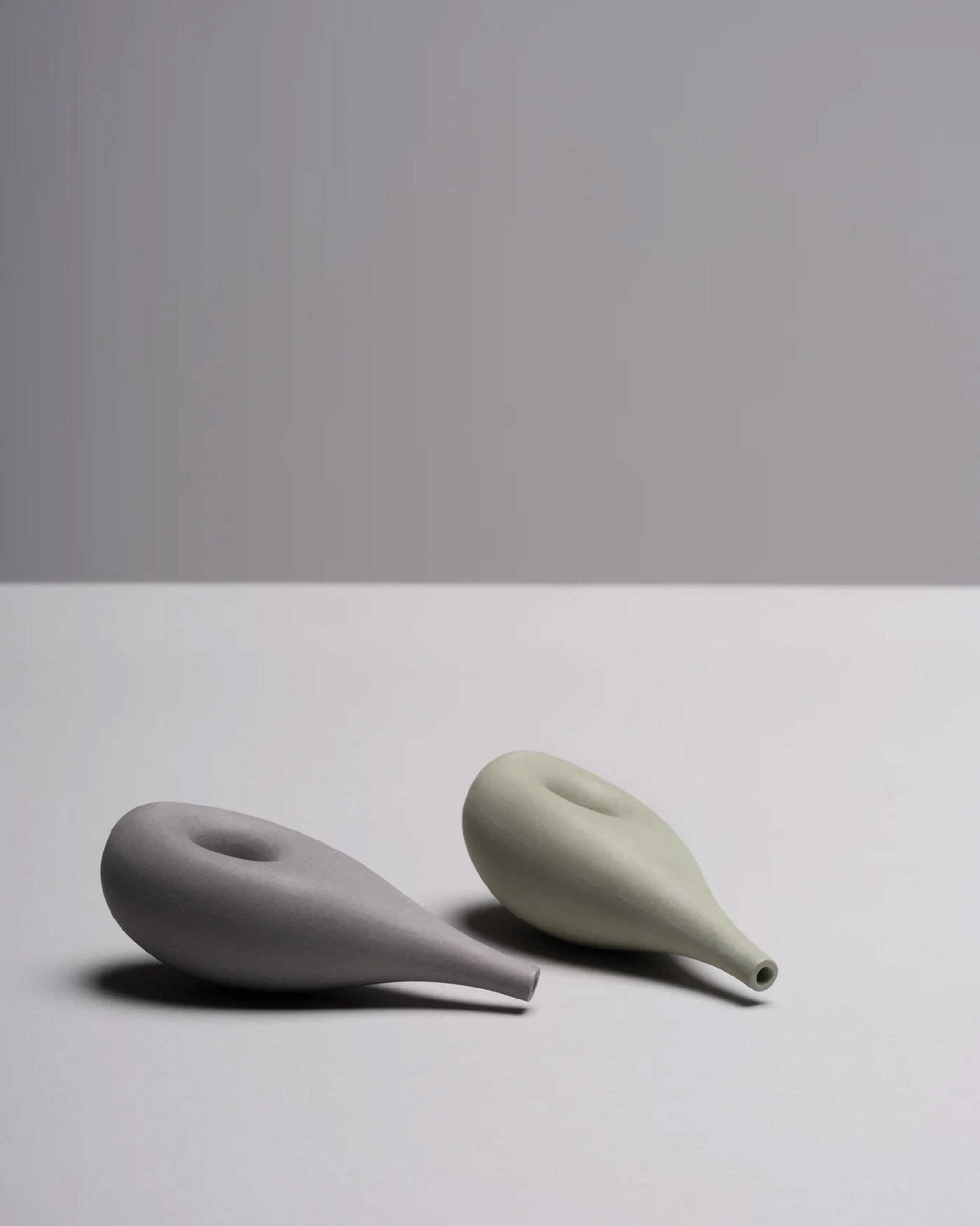 Pair of porcelain Cloud Pipes with soft, organic contours, displayed on a white background, blending function and form in minimalist design.