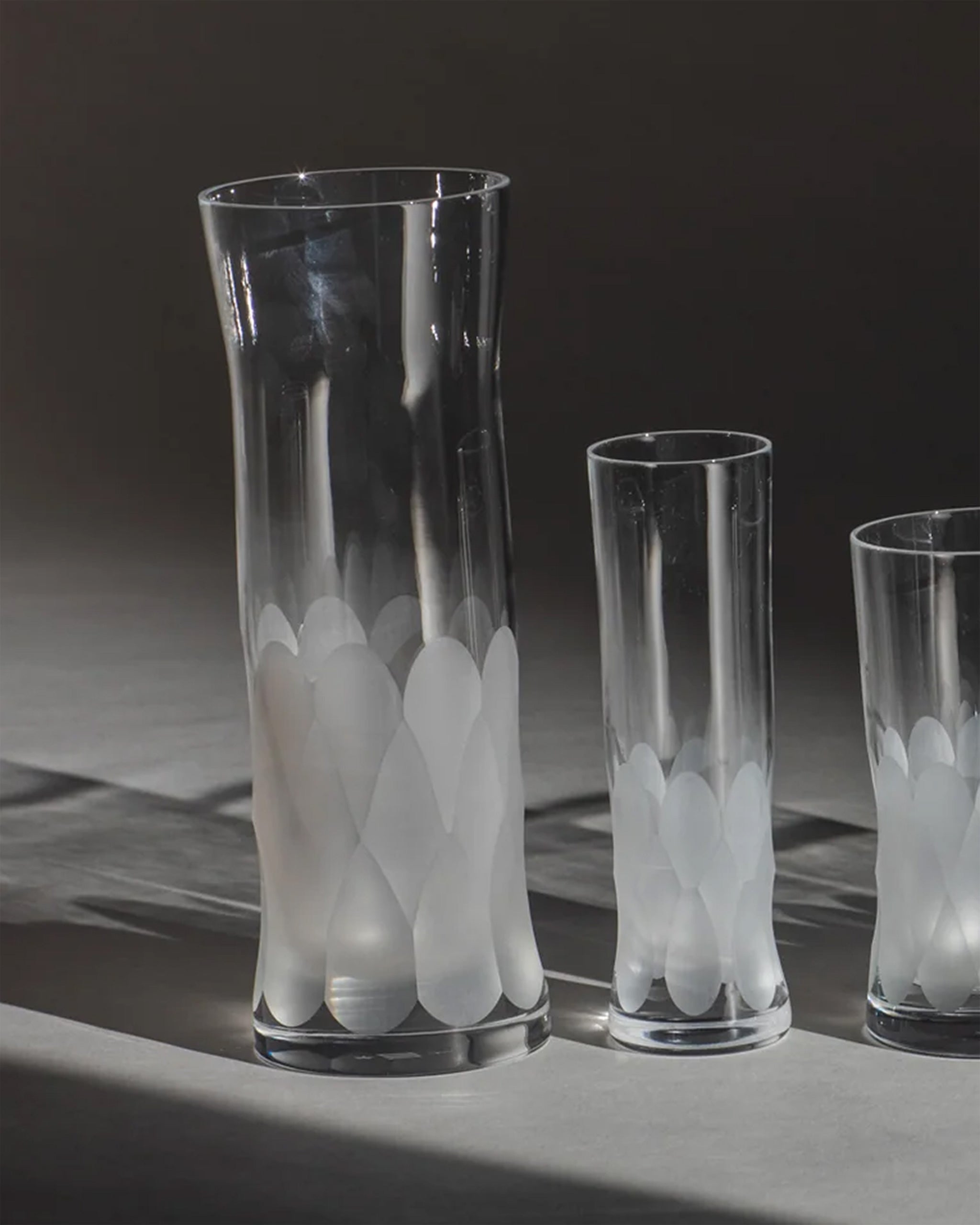Unpolished hand-cut Irish crystal glasses with softly polished and sandblasted dew-cut detailing on an ambient background