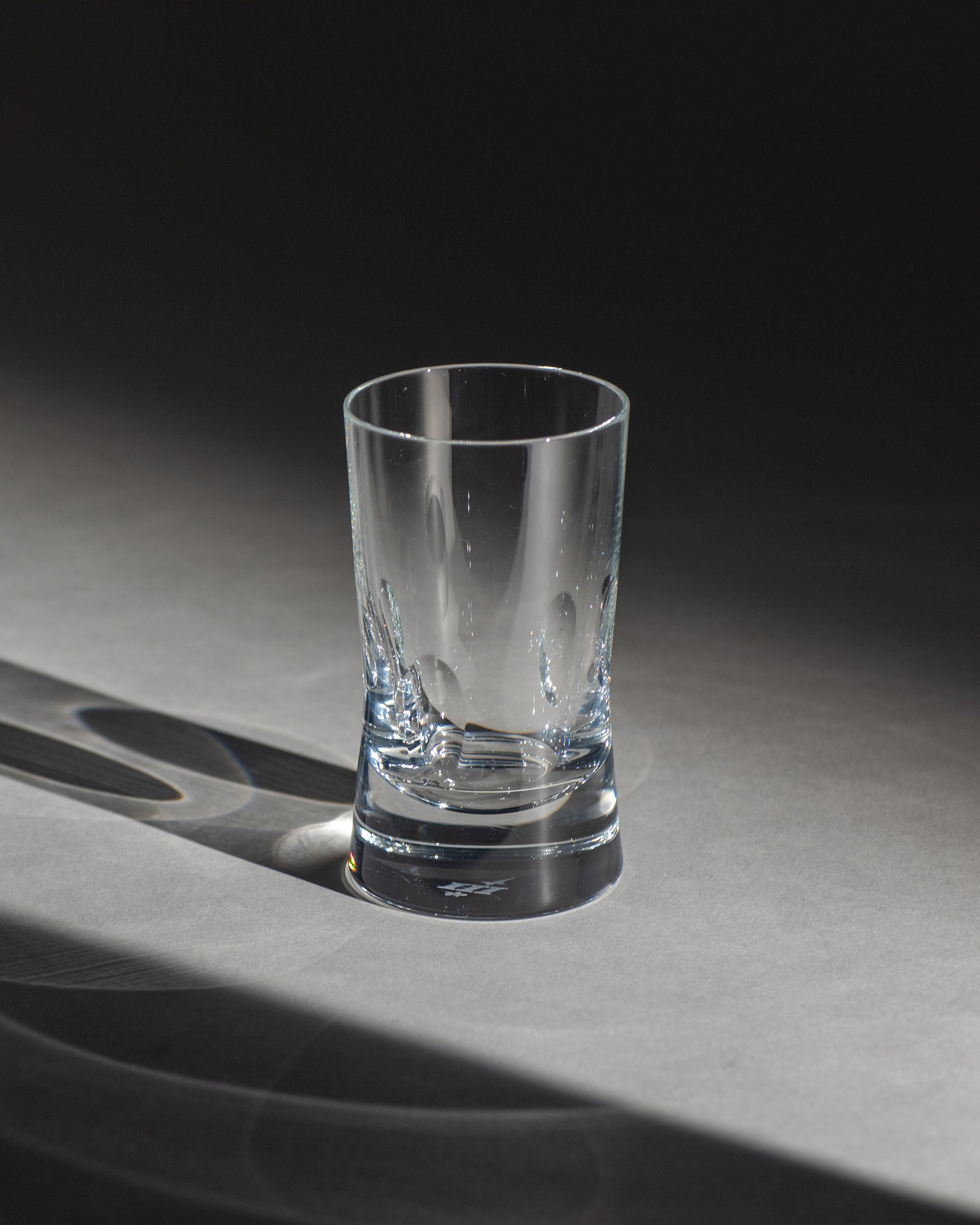 Polished hand-cut Irish crystal red wine glass with softly polished and sandblasted dew-cut detailing on an ambient background