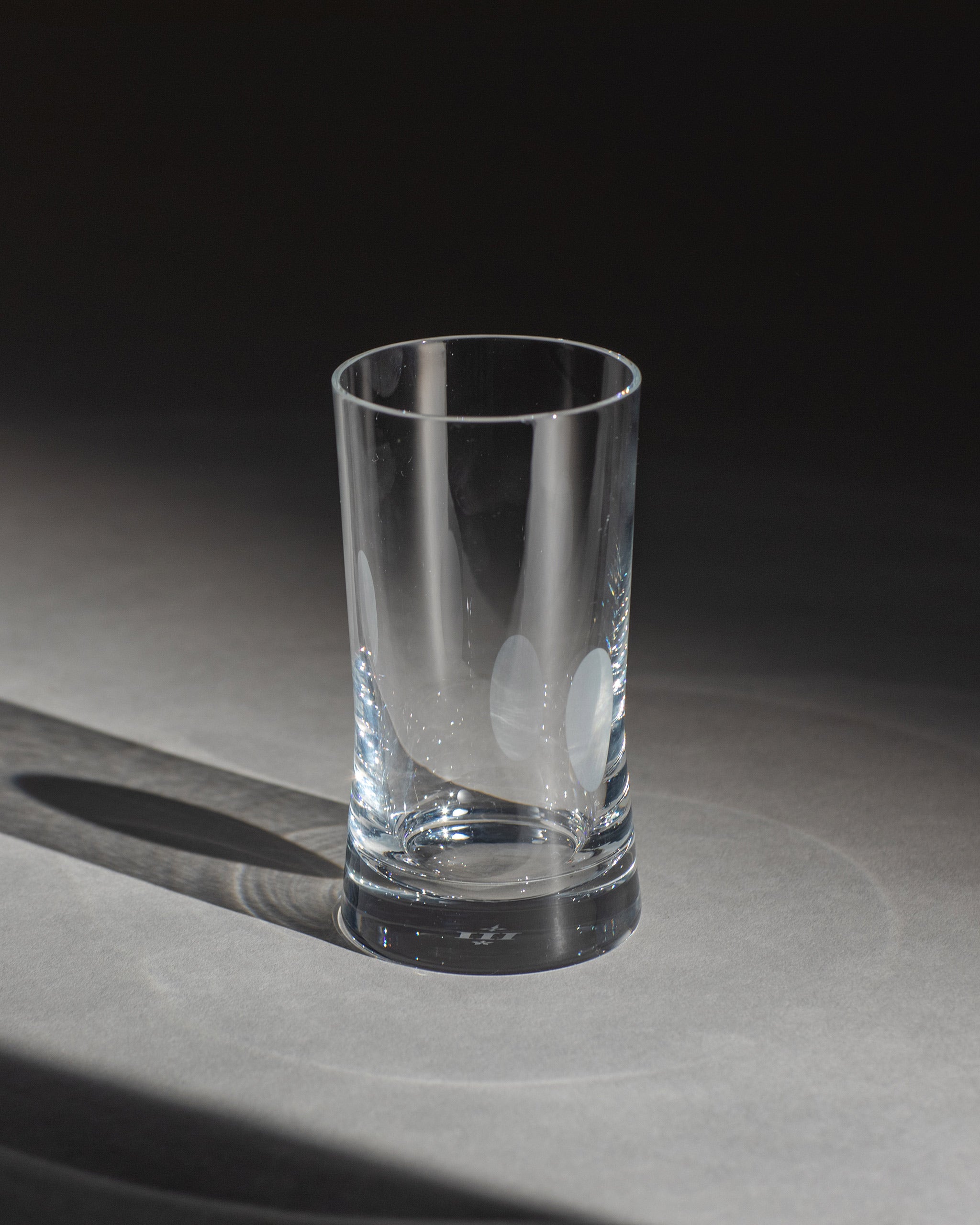 Unpolished hand-cut Irish crystal rocks tumbler glass with softly polished and sandblasted dew-cut detailing on an ambient background