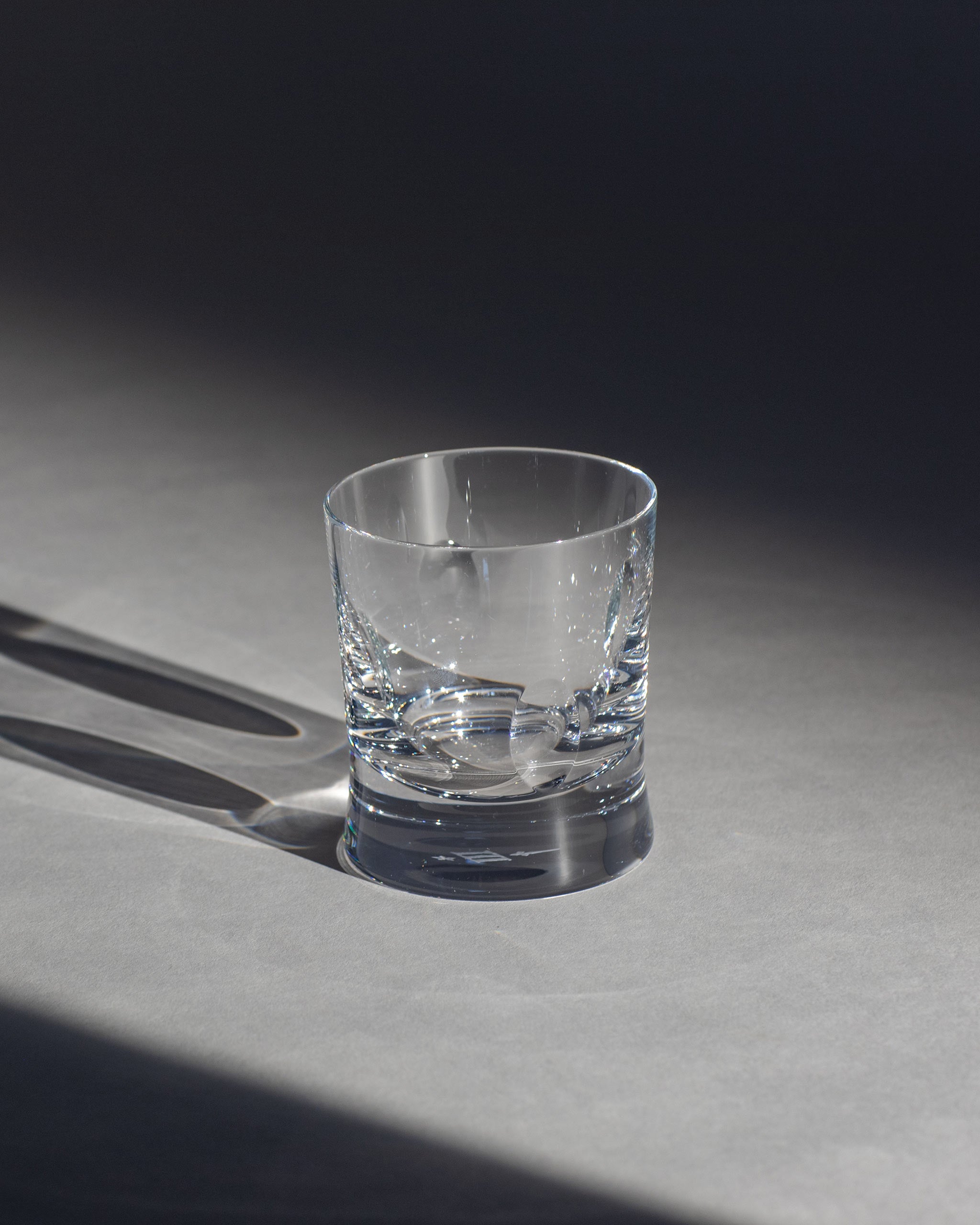 Polished hand-cut Irish crystal whiskey low glass with softly polished and sandblasted dew-cut detailing on an ambient background