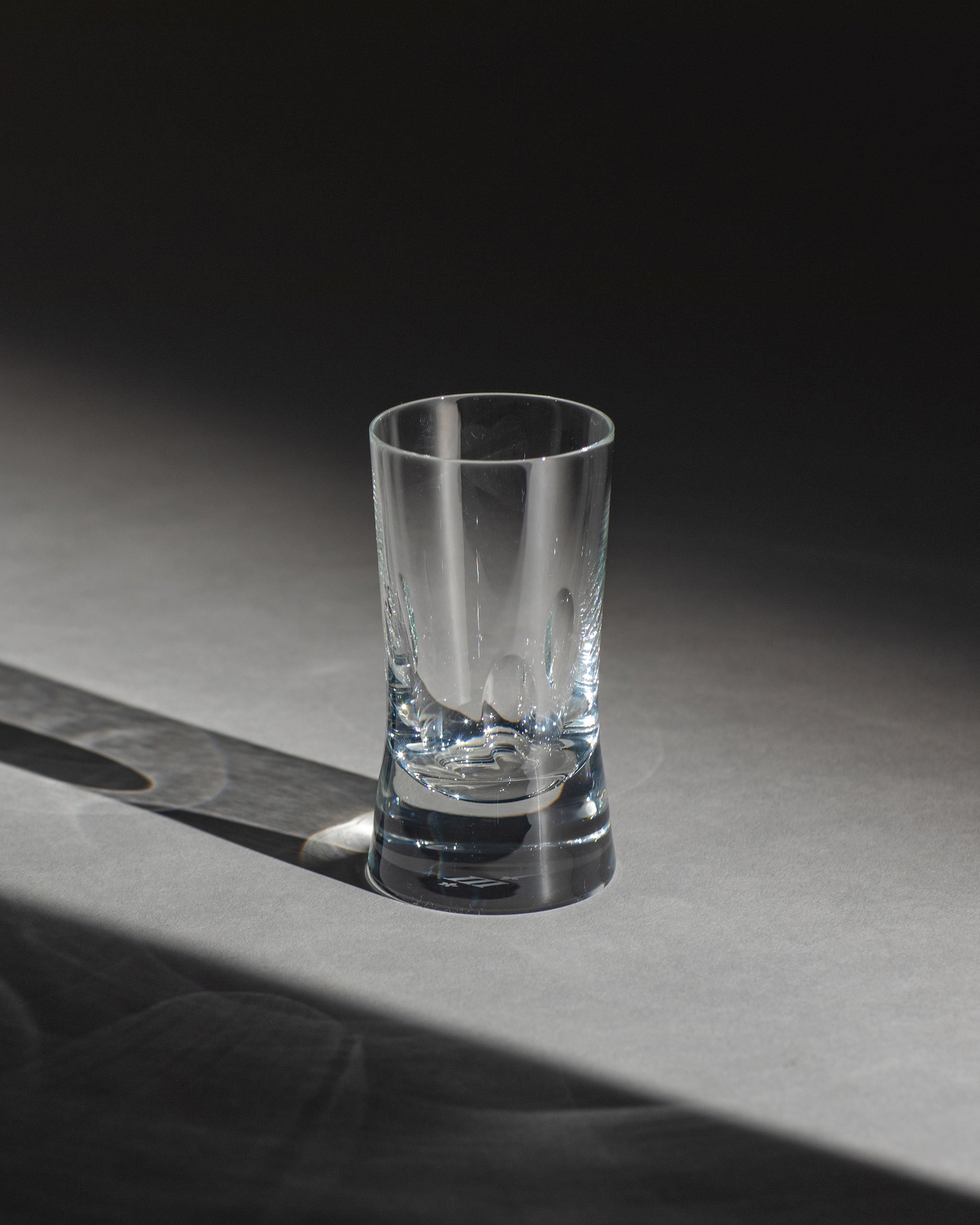 Polished hand-cut Irish crystal white wine or water glass with softly polished and sandblasted dew-cut detailing on an ambient background