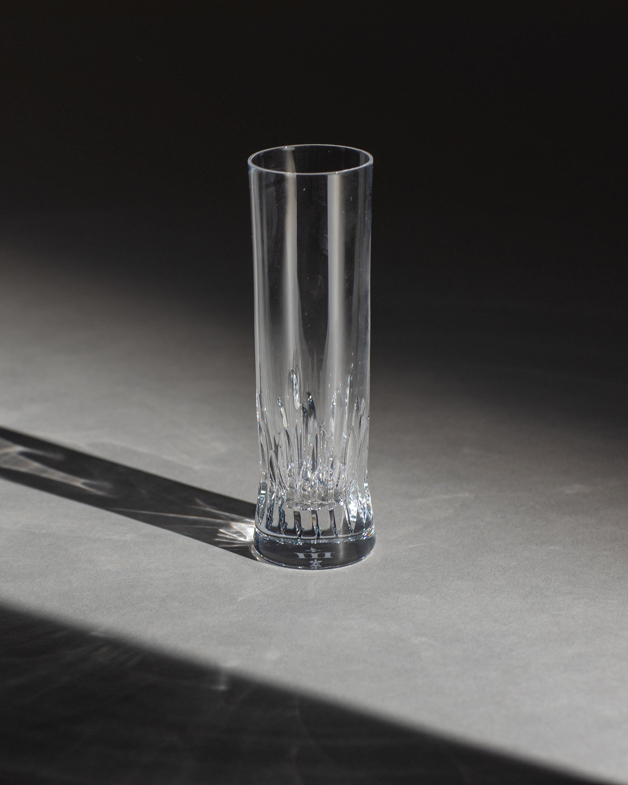 Polished hand-cut Irish crystal champagne flute with deep angular cuts inspired by ploughed soil on an ambient background