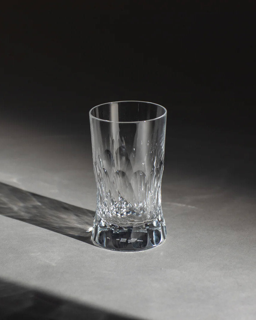 Polished Irish hand-blown crystal tumbler glass, with interlocking cut patterns on an ambient background