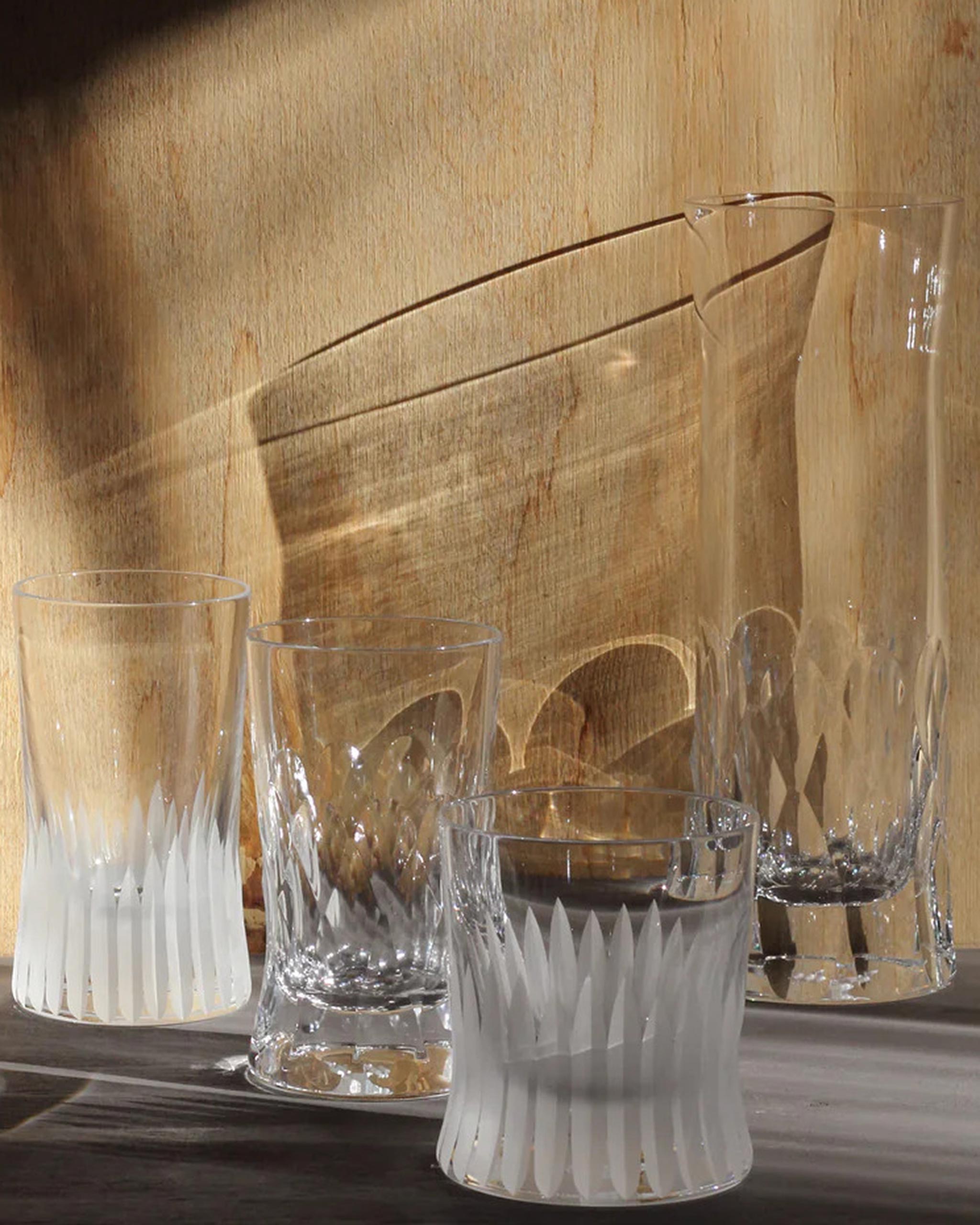 Array of Irish hand-blown cut crystal glasses on a warm wooden background