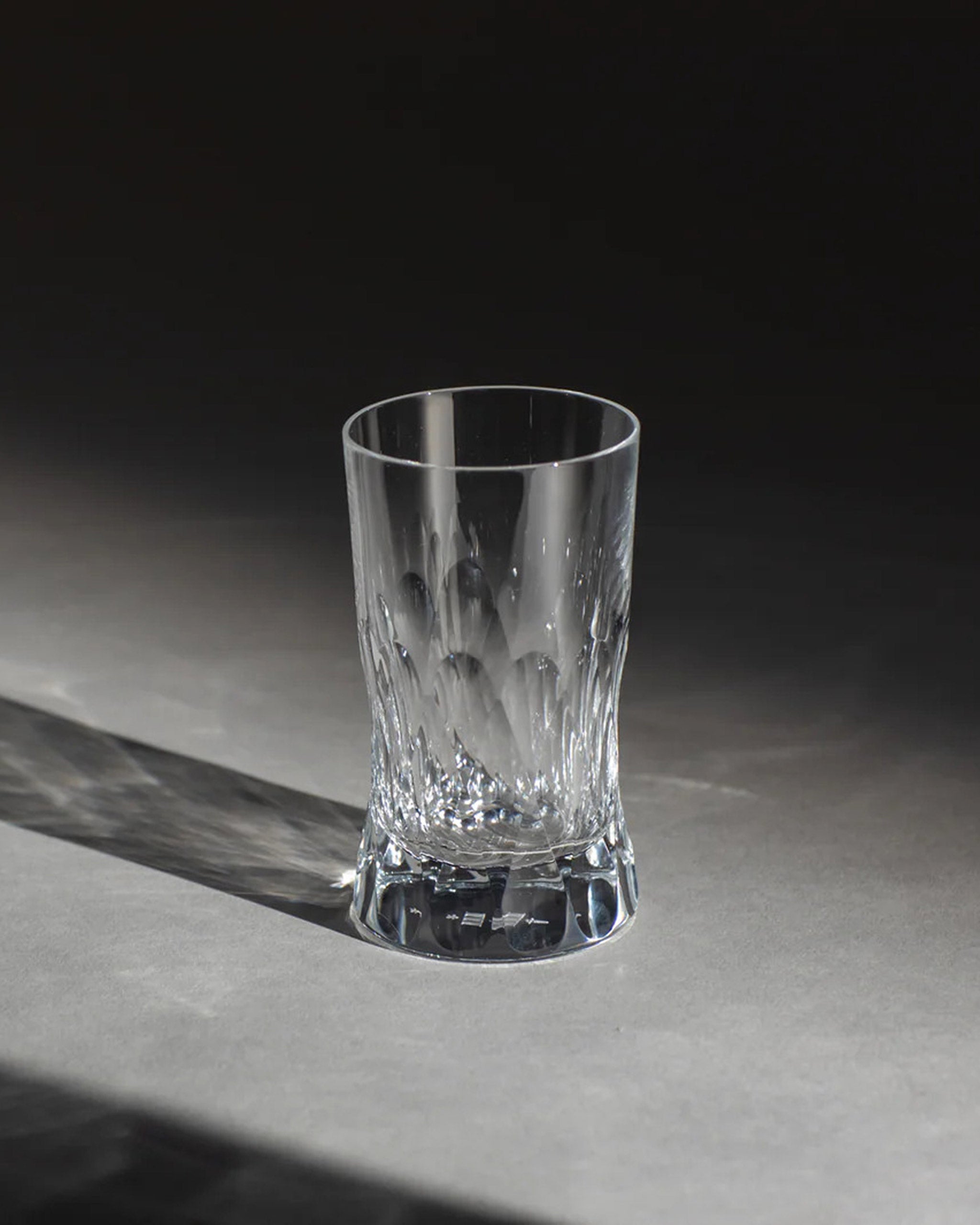 Polished Irish hand-blown crystal red wine glass, with interlocking cut patterns on an ambient background