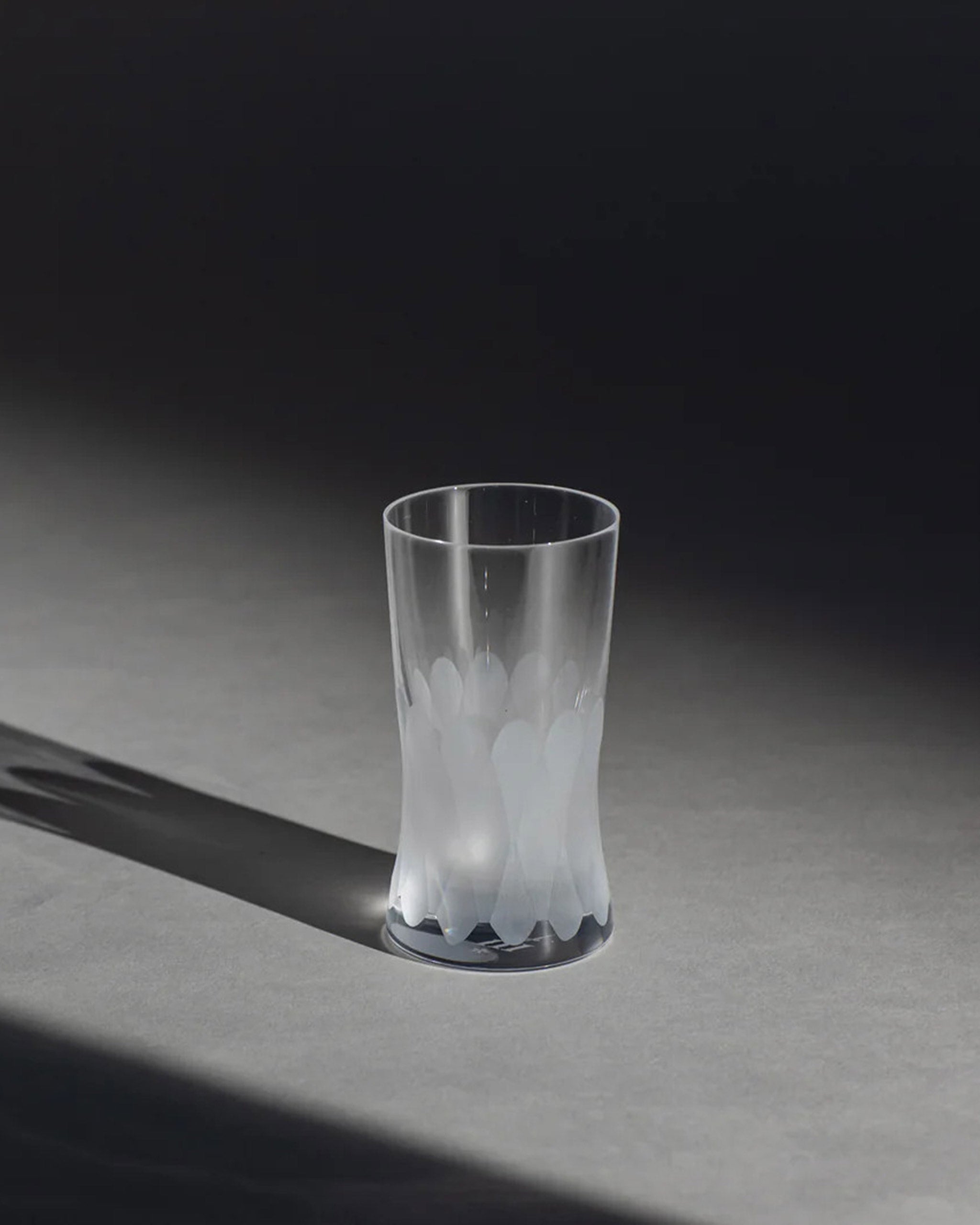 Unpolished Irish hand-blown cut crystal wine or water glass with large cut pattern detailing on an ambient background