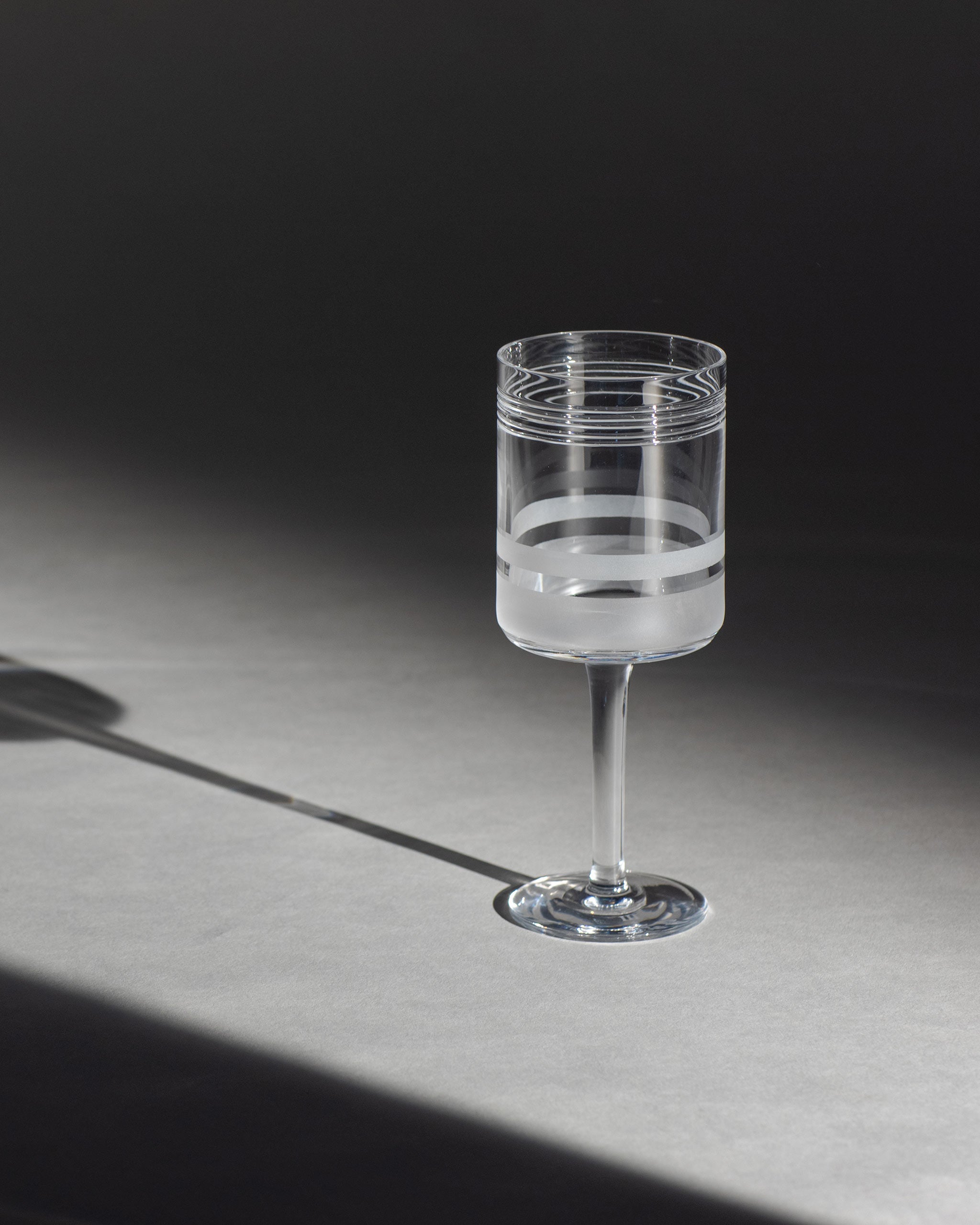 Red wine glass with cut crystal pattern and sandblasted panels on an ambient background